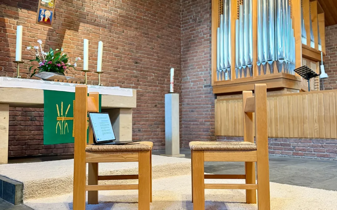 Zwei gegenüberstehende Stühle in der Bendestorfer Kirche, auf einem liegt ein Tablet – Symbolbild für KI, Seelsorge und menschliche Resonanz.